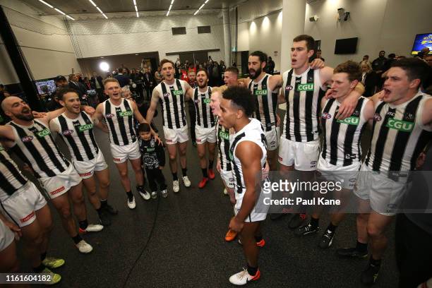 John Noble and Isaac Quaynor of the Magpies sing the club song with team mates after winning the round 17 AFL match between the West Coast Eagles and...