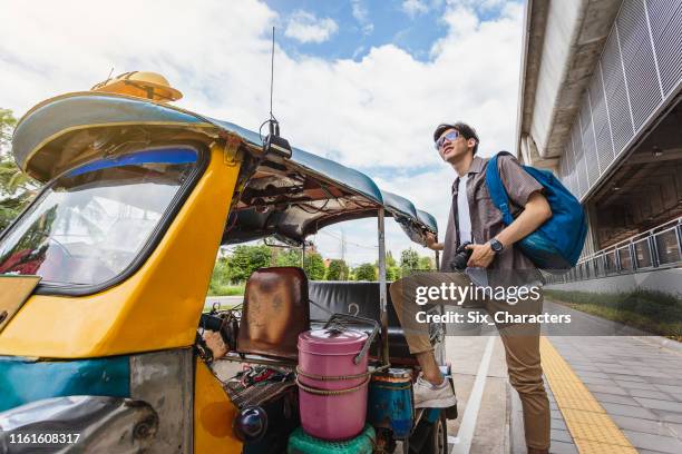 young asian traveller man standing with local tuk tuk taxi, khonkaen city, thailand - jinrikisha stock pictures, royalty-free photos & images