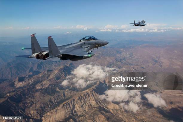 aviones de combate f-15 sobrevolando montañas - fighter plane fotografías e imágenes de stock