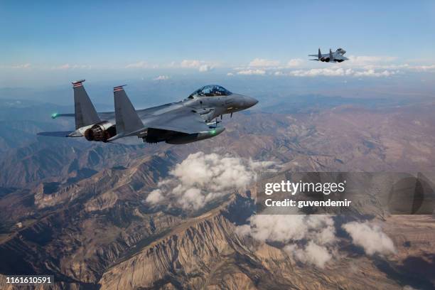 f-15 fighter jets flying over mountains - us military stock pictures, royalty-free photos & images