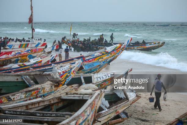Fishermen get on a fishing boat to sail off for fishing at the ocean in Nouakchott, Mauritania on August 11, 2019. Fishing is one of the most...