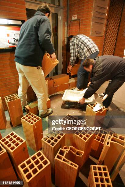 Des agriculteurs érigent un mur de brique devant la permanence toulousaine de l'UMP, dans la nuit du 18 au 19 avril 2006 à Toulouse, lors d'une...