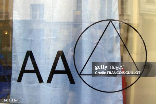 Vue prise le 23 janvier 2004 du logo de l'association Les Alcooliques anonymes sur la vitre de l'une des permanences de l'association à Paris. AFP...