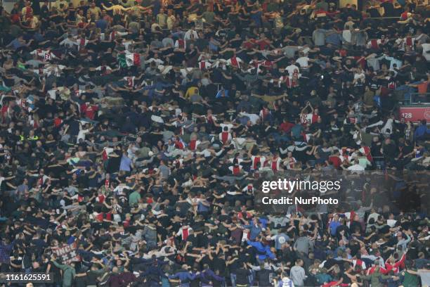 Crowd of AJAX's fans with their backs turned performing a celebration act during the FC AJAX Amsterdam vs PAOK Salonika football match game with...