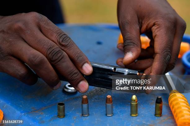 Anthony Wahome, Chairman of Kenya's National Gun Owners Association , prepares to load a magazine with ammunition including the catridge of a...
