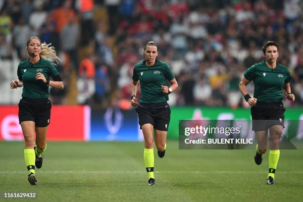 French referee Stephanie Frappart runs across the pitch together with French assistant referee Manuela Nicolosi and Irish assitant referee Michelle...