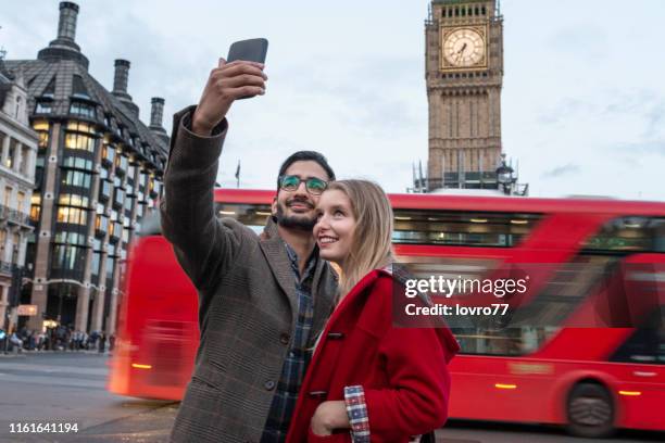 young tourist standing in front of big ben and doing selfie - london bus big ben stock pictures, royalty-free photos & images