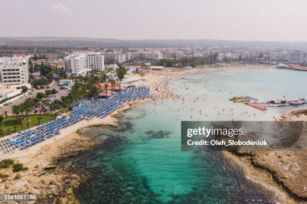 scenic aerial view of beach with blue umbrellas on cyprus - republic of cyprus stock pictures, royalty-free photos & images