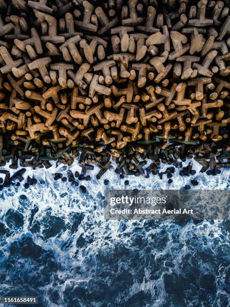 ocean crashing against tetrapod structure, north wales, united kingdom - guards division stock pictures, royalty-free photos & images