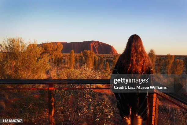 Man looks out from the sunrise viewing area at Uluru on August 12, 2019 in the Uluru-Kata Tjuta National Park, Australia. The Uluru-Kata Tjuta...