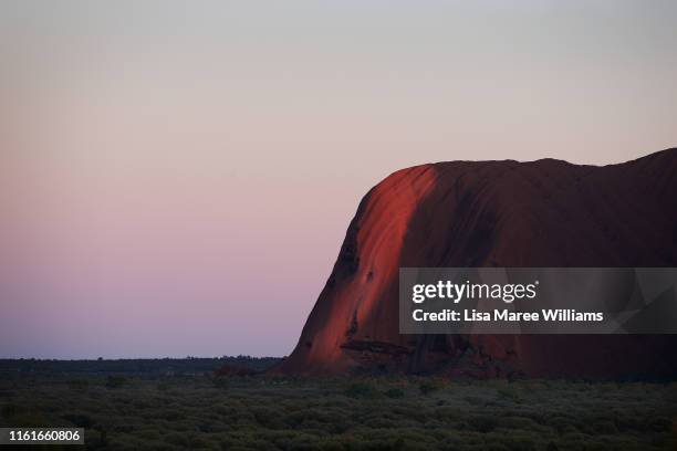 General view of Uluru as seen from the designated sunrise viewing area at Uluru on August 14, 2019 in the Uluru-Kata Tjuta National Park, Australia....