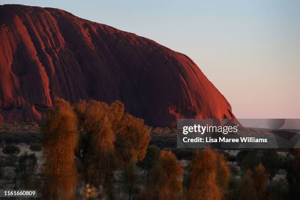 General view of Uluru as seen from the designated sunrise viewing area at Uluru on August 14, 2019 in the Uluru-Kata Tjuta National Park, Australia....