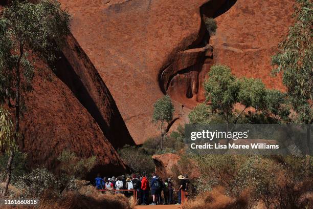 Visitors commence the Mala Walk trail at Uluru on August 12, 2019 in the Uluru-Kata Tjuta National Park, Australia. The Uluru-Kata Tjuta National...