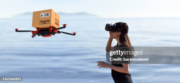 young women using delivery drone with vr - drone parcel stock pictures, royalty-free photos & images