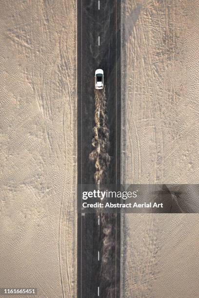 car driving on a desert road, united arab emirates - aerial view photos fotografías e imágenes de stock