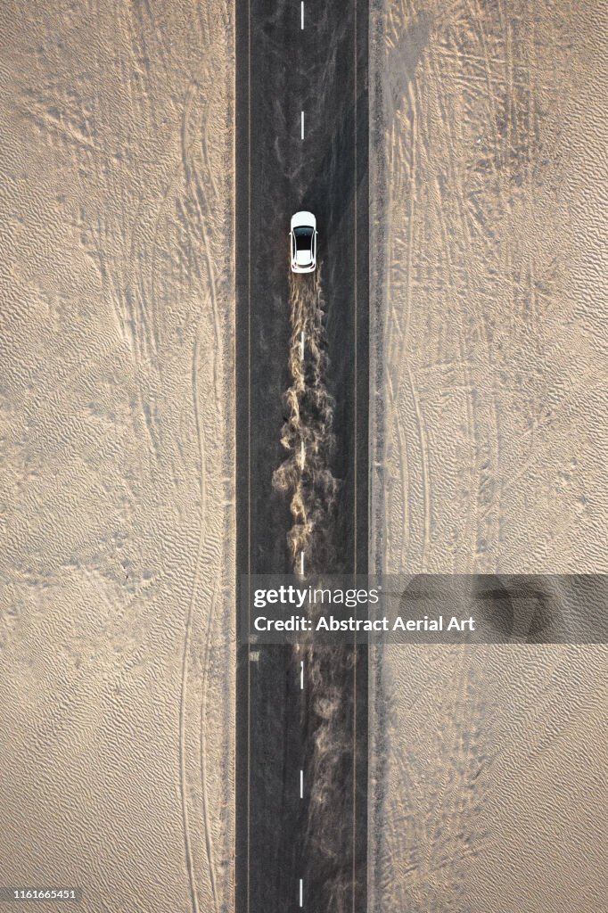 Car driving on a desert road, United Arab Emirates