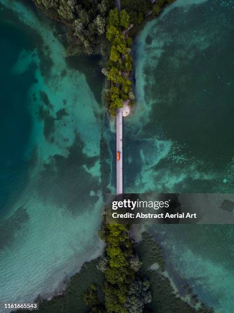 drone shot looking down on a bridge crossing over lake konstanz, bavaria, germany - drone images stock-fotos und bilder