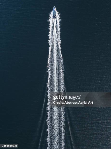 aerial image of a speed boat moving quickly across the ocean, hong kong - navegación en yate fotografías e imágenes de stock