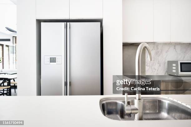 kitchen in a modern luxury condo - refrigerator stock pictures, royalty-free photos & images