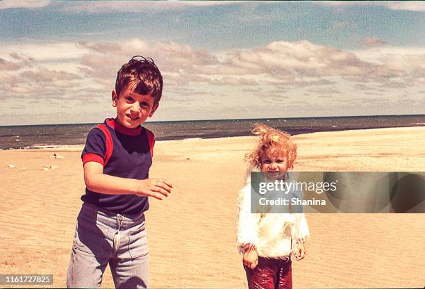 kalter tag am strand - girl blowing sand stock-fotos und bilder