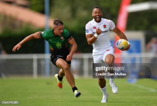 Dan Norton of England makes a break past Matas Miezys of Lithuania to score a try during the Group C match between England and Lithuania on day one...