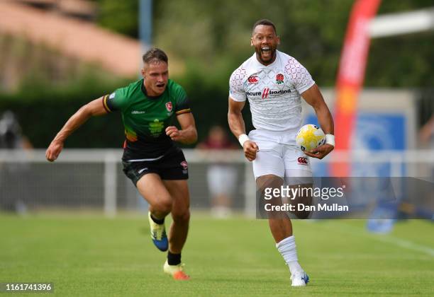 Dan Norton of England makes a break past Matas Miezys of Lithuania to score a try during the Group C match between England and Lithuania on day one...