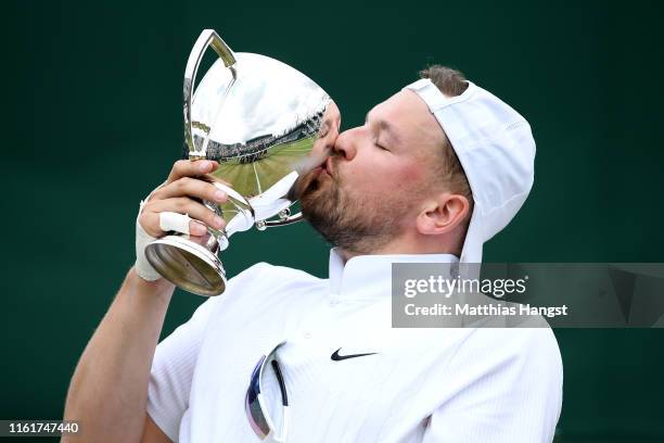 Dylan Alcott of Australia kisses the winners trophy after celebrating victory in the Men's Quad Wheelchair Singles final against Andy Lapthorne of...