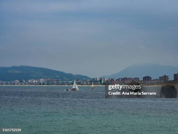 coastal landscape with a boat sailing between laredo y santoña in cantabria (spain) - laredo stockfoto's en -beelden