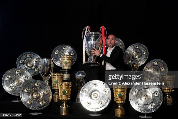 Franck Ribery poses for a picture with all his trophys won with the FC Bayern Muenchen team during an event at FCB Erlebniswelt on May 28, 2019 in...