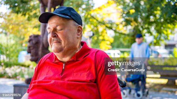 senior man sleeping in public park - man sleeping with cap stock pictures, royalty-free photos & images