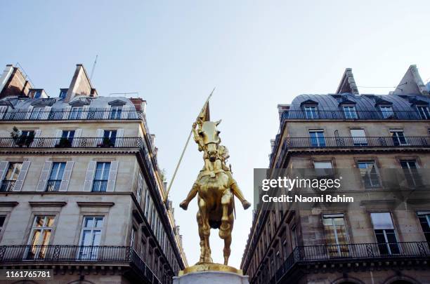 joan of arc gilded bronze equestrian sculpture and haussmann apartments in paris, france - place des pyramides stock pictures, royalty-free photos & images