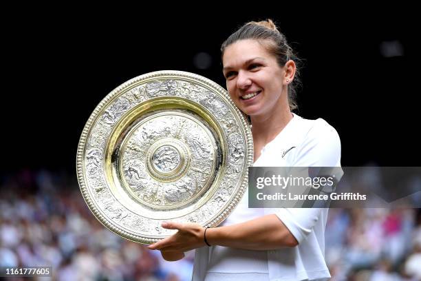 Simona Halep of Romania shows off the trophy after winning the Ladies' Singles final against Serena Williams of The United States during Day twelve...