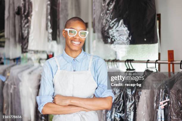 portrait of young woman at dry cleaning shop - dry cleaning shop stock pictures, royalty-free photos & images