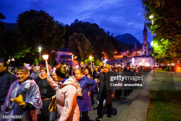 massen von gläubigen, die an einem abendlichen chaos in lourdes, frankreich teilnehmen - lourdes stock-fotos und bilder