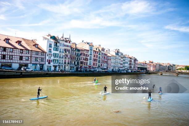 people paddleboarding on nive river in bayonne, france - bayonne imagens e fotografias de stock