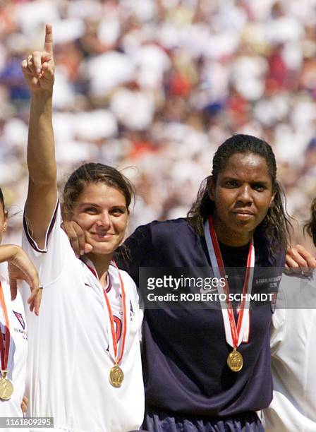 Mia Hamm of the US signals number one along with goalie Briana Scurry during the gold medal ceremony after defeating China in a penalty kick...