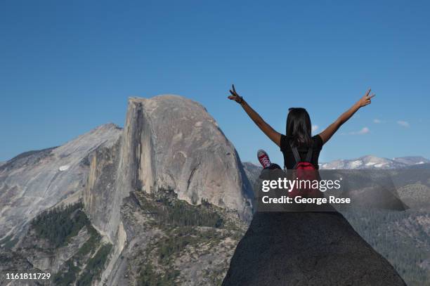 People take pictures at Glacier Point with Half Dome as a backdrop on July 1 in Yosemite Valley, California. With the arrival of summer, visitors are...
