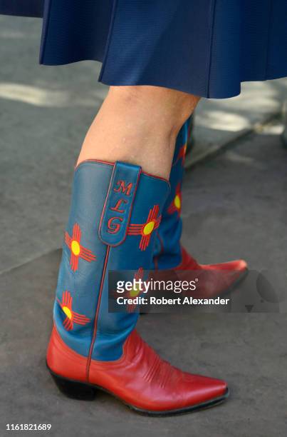 Michelle Lujan Grisham, the governor of New Mexico, wears boots embellished with her initials as she talks with supporters at a Fourth of July event...