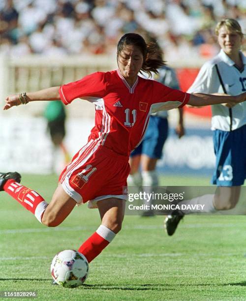 Chinese midfielder Pu Wei shoots on goal as Russian midfielder Elena Fomina looks on during their 30 June 1999 Women's World Cup match in San Jose,...