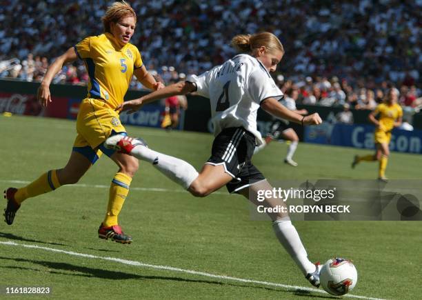 Germany's Nia Kuenzer drives past Sweden's Kristin Bengtsson in the second half of Germany's 2-1 win over Sweden in the final at the FIFA 2003...