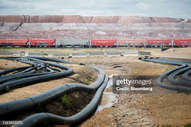 Rail cars sit on tracks in front of a tailings pile at the Nutrien Ltd. Cory potash facility in Saskatoon, Saskatchewan, Canada, on Monday, Aug. 12,...