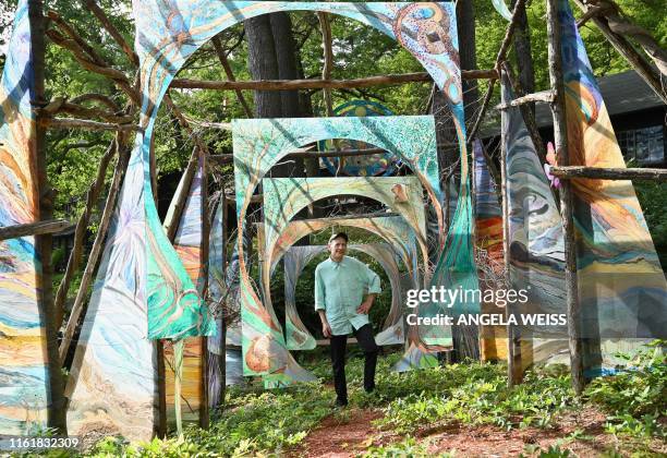 Alan Baer, Architect and curator of the exhibition 'Psych Out!!!' poses for a picture with artist Susan Togut's installation 'Seasons of...