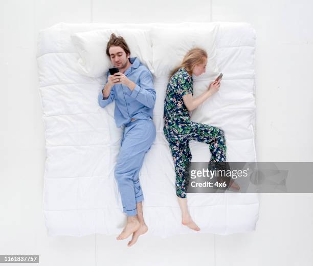 couple in bed using smart phone - bed on white stock pictures, royalty-free photos & images