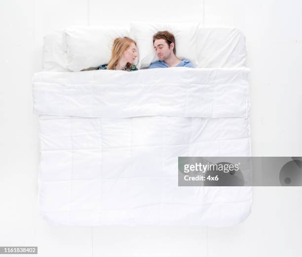 happy couple is in bed together - above view of man sleeping on bed stock pictures, royalty-free photos & images