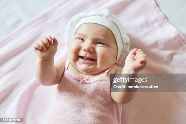 schattige baby meisje kietelen op roze deken - jongensbaby's stockfoto's en -beelden