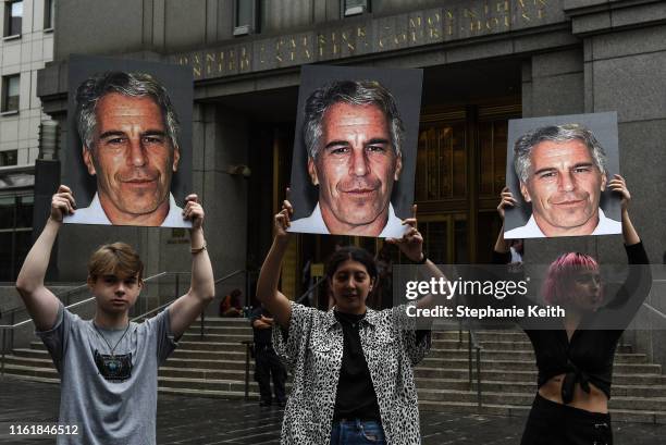 Protest group called "Hot Mess" hold up signs of Jeffrey Epstein in front of the Federal courthouse on July 8, 2019 in New York City. According to...