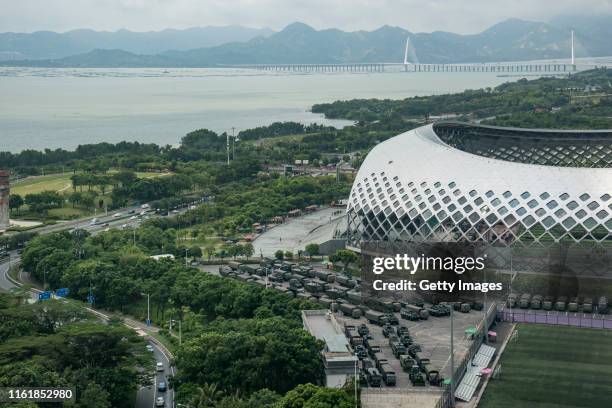 Trucks and armoured personnel vehicles park outside the Shenzhen Bay stadium on August 16, 2019 in Shenzhen, China. Pro-democracy protesters have...