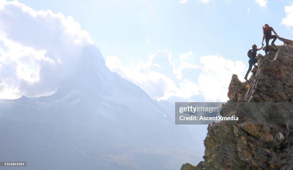 Los excursionistas se suben por una colina empinada cerca del pico Matterhorn