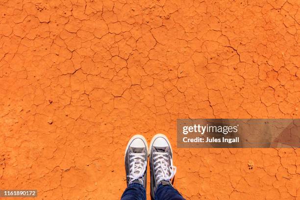 view of feet against the red desert landscape in australia - northern territory stock pictures, royalty-free photos & images