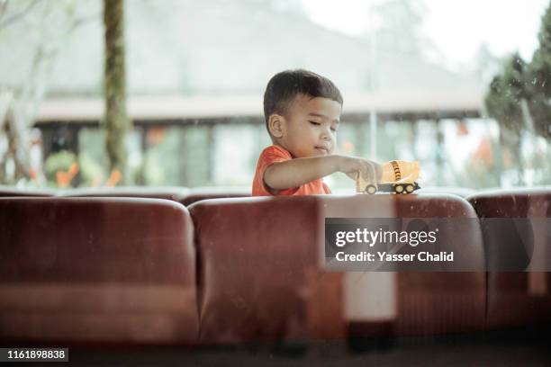 toddler son through glass window - auto sofa stock-fotos und bilder